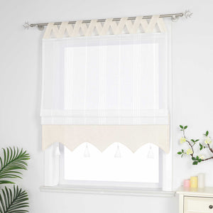 Beige und weisse Raffrollo Gardine mit Schlaufen dekorativen Quasten und geschwungenem Saum halb hochgezogen, Seitenansicht eines weißen Raffrollos mit Quasten und Schlaufen – halb geschlossen, sodass die Fenster nicht vollständig bedeckt sind, neben Grünpflanzen und duftenden Ornamenten.