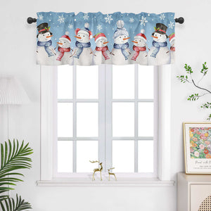 Die blaue Weihnachts-Scheibengardine mit Schneemann-Motiven bringt eine fröhliche und winterliche Atmosphäre in den Raum. Die Schneemänner und kleinen Schneeflocken sind mit pragmatischer Drucktechnik auf den Stoff aufgebracht, was ihnen klare Konturen und eine lebendige Darstellung verleiht. Diese Lichtschutzgardine hängt vor einem weißen Fenster und sorgt für eine gemütliche Weihnachtsstimmung. Die weiße Wand und grünen Pflanzen im Raum ergänzen das Design und bringen die festlichen Elemente perfekt zur G