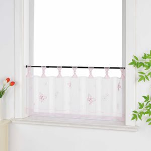 Seitliche Ansicht eines rosa transparenten Kurzvorhang mit dekorativen Perlen an den Aufhängeschlaufen und Schmetterlingsmuster auf der Oberfläche. Der Vorhang hat ein rosa Dekoband am unteren Rand und ist vor einem Fenster mit einem Schrank und Blumen als Dekoration aufgehängt.