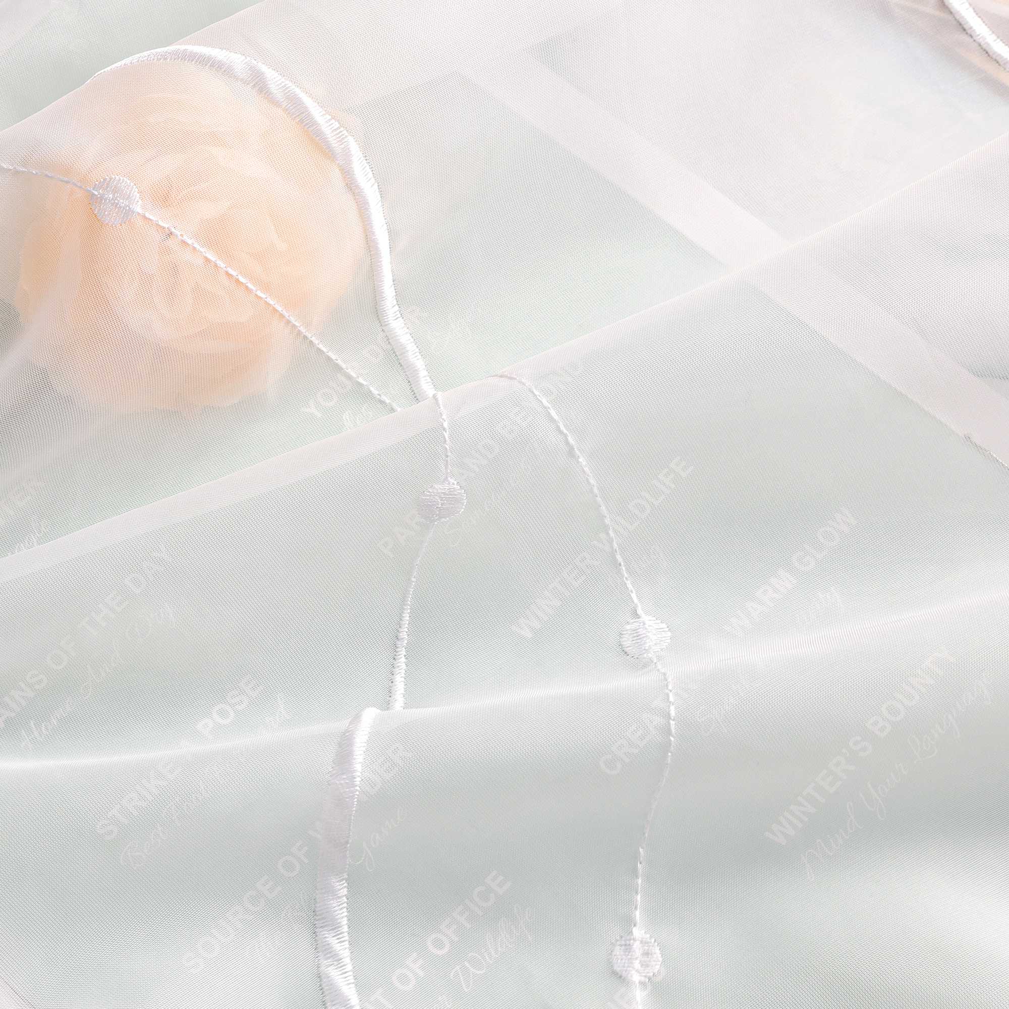 Ein weiteres Bild zeigt die Stoffstruktur der Gardine im Detail: leicht, atmungsaktiv und transparent in Netzoptik. Verziert ist sie mit feinen weissen Wellenlinien und kleinen weissen Punkten am Linienende. Der Hintergrund ist hellgruen.