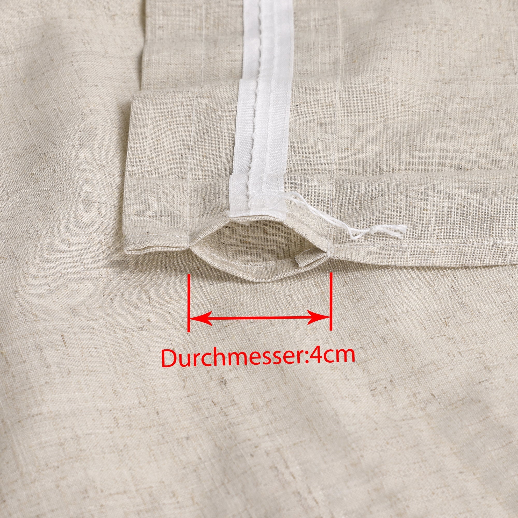 Dies ist ein Detailbild des Vorhangstoffs, das den Bereich des Vorhangs mit der Aufhängung zeigt. Der Durchmesser des Durchzugslochs beträgt 4 cm, was die Anpassung an Vorhangstangen der entsprechenden Größe erleichtert. Der Stoff hat eine cremeweiße Farbe und erinnert an Leinen.