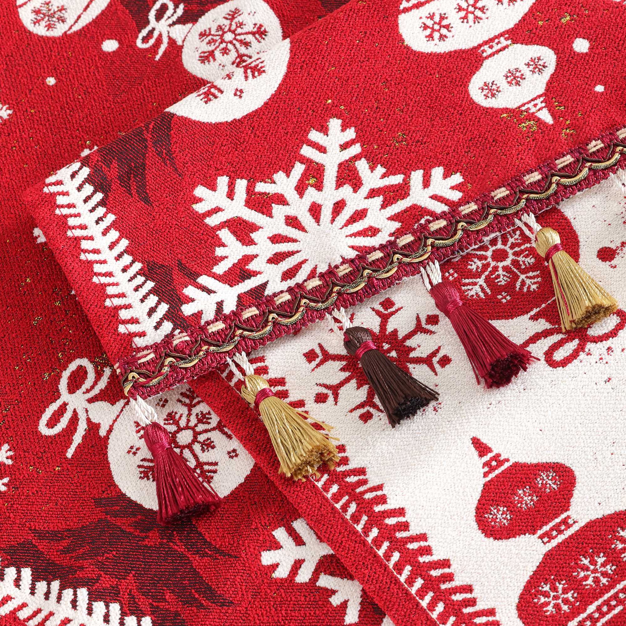 Dieses Bild zeigt die Details des Weihnachts-Tischläufers, besonders die feinen Fransenverzierungen. Der Rand des Tischläufers ist mit goldenen und dunkelroten Fransen geschmückt, was einen eleganten Touch verleiht und perfekt mit dem kräftigen roten Hintergrund sowie den Schneeflocken- und Weihnachtsbaumkugel-Mustern harmoniert. Die Jacquard-Webtechnik sorgt für klare und plastische Muster und hebt die hohe Qualität des Gewebes hervor.