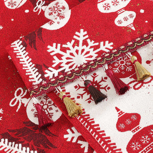 Dieses Bild zeigt die Details des Weihnachts-Tischläufers, besonders die feinen Fransenverzierungen. Der Rand des Tischläufers ist mit goldenen und dunkelroten Fransen geschmückt, was einen eleganten Touch verleiht und perfekt mit dem kräftigen roten Hintergrund sowie den Schneeflocken- und Weihnachtsbaumkugel-Mustern harmoniert. Die Jacquard-Webtechnik sorgt für klare und plastische Muster und hebt die hohe Qualität des Gewebes hervor.