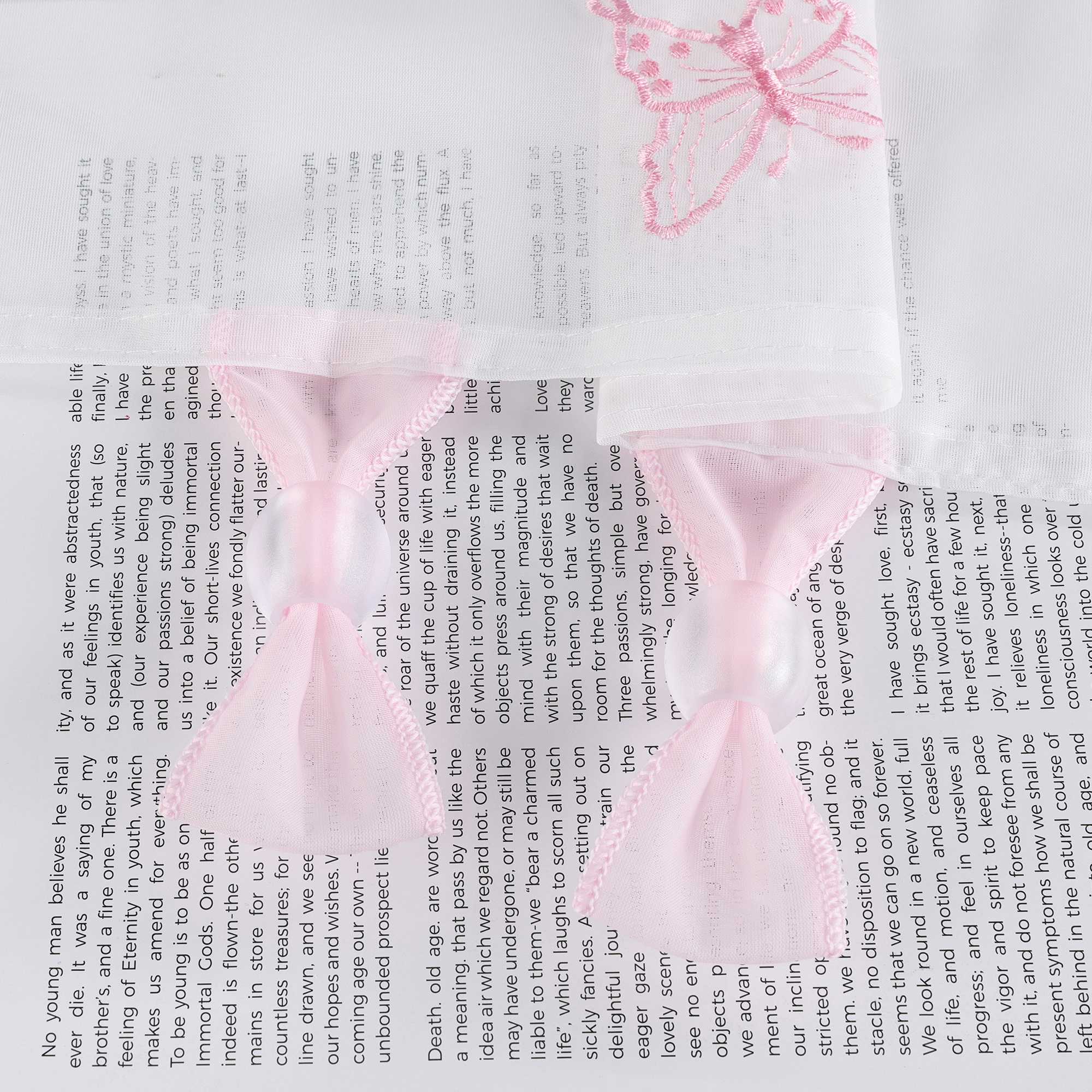 Nahaufnahme der transparenten Perlen, die an der oberen rosa Aufhängeschlaufe des Vorhangs befestigt sind, wobei die Perlen direkt mit der Schlaufe verbunden sind.