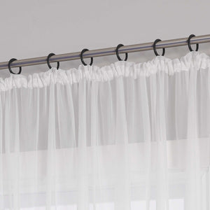 Eine Metallgardinenstange mit schwarzen Ringen, an denen ein weißer Vorhang mit Kräuseln aus transparentem Stoff aufgehängt ist. Der Vorhang hat am oberen Ende ein gerafftes Design.