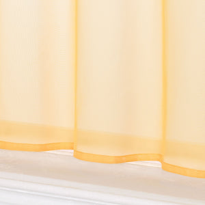 Dies ist eine Nahaufnahme des unteren Teils eines gelben, transparenten Vorhangs. Der Stoff ist leicht und durchsichtig, mit gelbem Saum am unteren Rand und einem weißen Fensterbrett darunter.